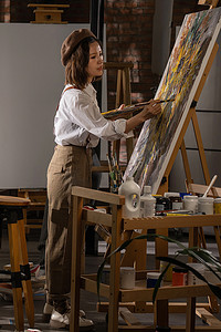 年轻的女画家在工作室绘画