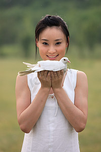 东方女人户外手捧和平鸽