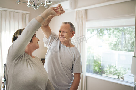 You make me feel young. a mature couple slow dancing in their lounge