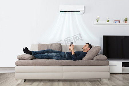 空调电脑摄影照片_男人躺在沙发上 