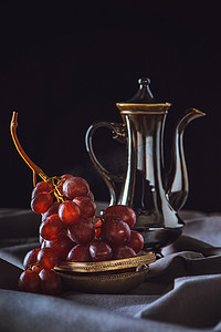 红葡萄摄影照片_黑色老式土耳其茶壶的红葡萄特写镜头