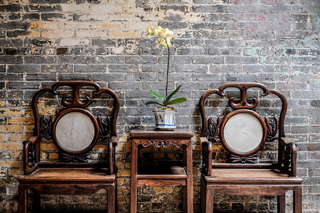 澳门建筑摄影照片_传统东方中国的传统建筑，木桌旁边，主持及装饰用美丽的兰花，在澳门，中国