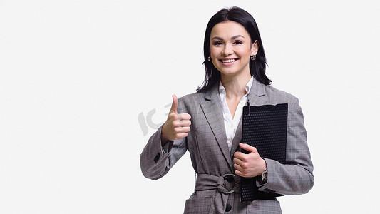 Smiling businesswoman with clipboard showing like gesture isolated on white