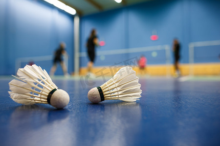 羽毛球-羽毛球与球员相互竞争，在前景毽子