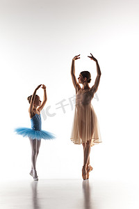 dance摄影照片_The little ballerina dancing with personal ballet teacher in dance studio