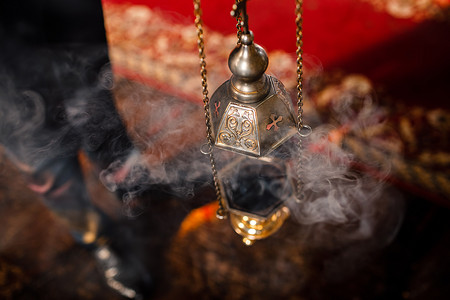 一个牧师的香炉挂在东正教教堂的一面旧墙上。里面有烧煤的铜香.为东正教的概念服务。敬拜