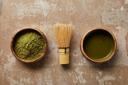 木碗中火柴茶和粉末的顶视图，在老化表面用竹须