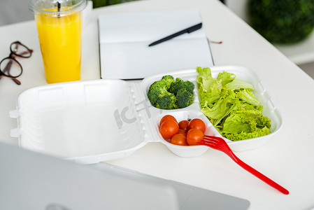 美味的有机蔬菜附近的塑料叉子和笔记本与笔