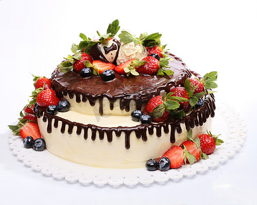白色背景的草莓和蓝莓装饰的巧克力慕斯蛋糕