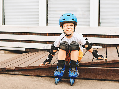 男孩坐轮滑鞋在室外公园夏天天
