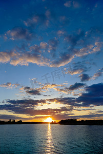落日天空背景摄影照片_蓝蓝的天空背景上湖落日