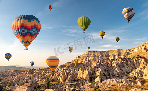 热气球小熊云小树摄影照片_飞越土耳其戈雷梅Cappadocia上空的热气球