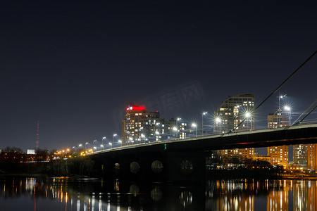 城市景观与照亮的桥梁以上的河流在夜间