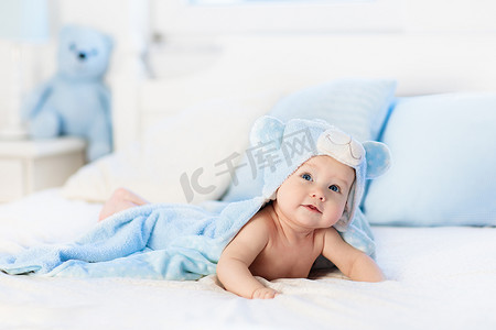 小男孩在蓝色毛巾在白色床上