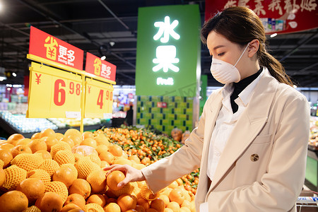 水果超市促销摄影照片_戴口罩的青年女人在超市购买水果