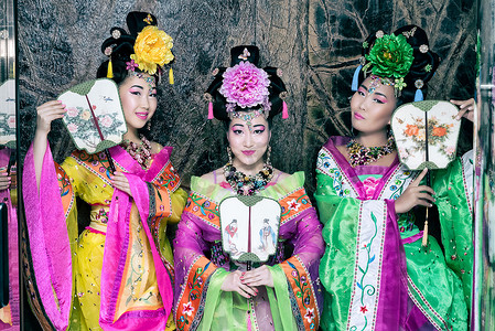 三个亚洲美女穿着日本和服，举行传统的球迷