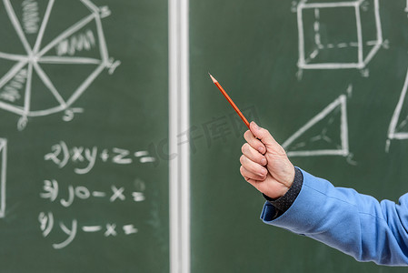 高级教授在黑板上用铅笔指着某物的裁剪图像