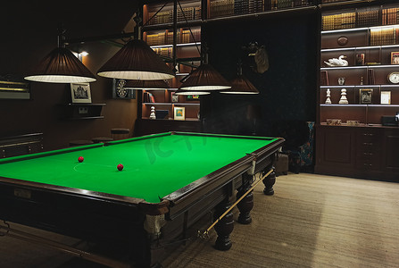 在一个古典风格的游戏室里有一个全尺寸的斯诺克/台球桌