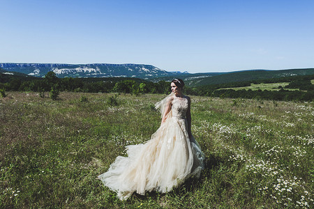 时尚新娘在绿色的原野的肖像 