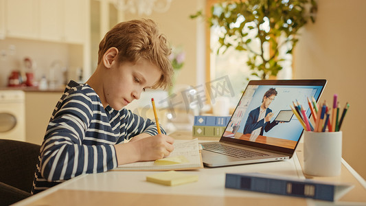 科目二五项摄影照片_聪明的小男孩和他的老师用笔记本电脑进行视频通话。屏幕显示在线讲座与教师解释科目从课堂上。电子教育远程学习、家庭教育.