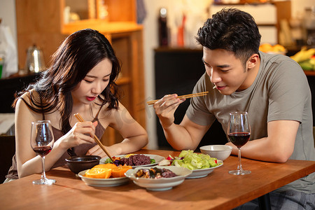 餐饮喝酒摄影照片_年轻夫妇在家用餐