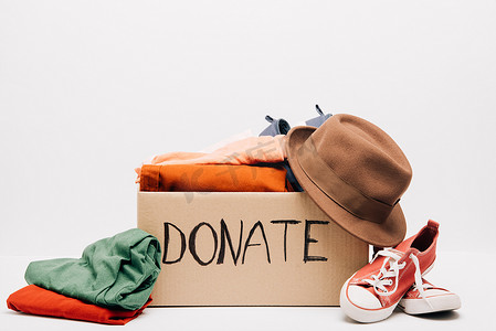 捐赠支票摄影照片_纸板箱，装有捐赠的衣服和鞋子，以白色、慈善概念隔离