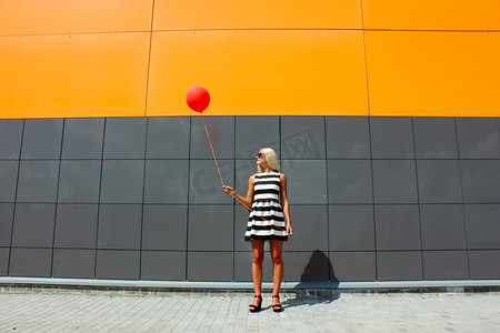 挂墙摄影照片_女孩站在附近的气球挂墙镜