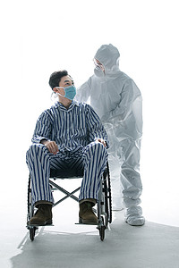医务人员职业防护摄影照片_医务工作者推着坐轮椅的患者