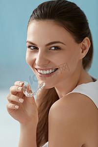 牙科护理。微笑的女人使用可移动的透明牙齿支架