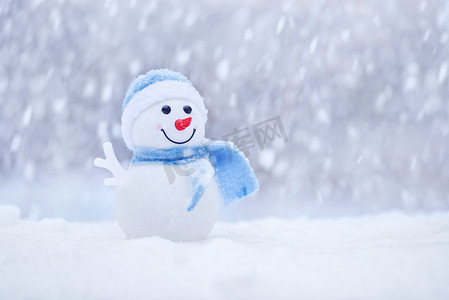 复印摄影照片_冬天, 戴着帽子戴着围巾的小雪人在雪地上。快乐的雪人与雪球。圣诞卡, 复印空间