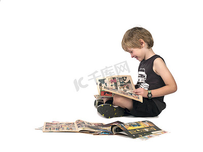 漫画描边摄影照片_一个男孩读漫画书的侧面图