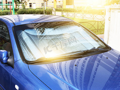 在炎热的一天，在车内被太阳光线加热的客车挡风玻璃下的保护性反射表面.