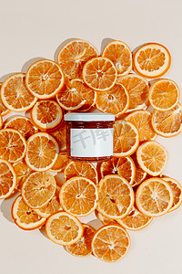 抗衰老摄影照片_在橙子干的背景上,有一层厚厚的润肤面霜.抗衰老作用的有机手工维生素C产品.