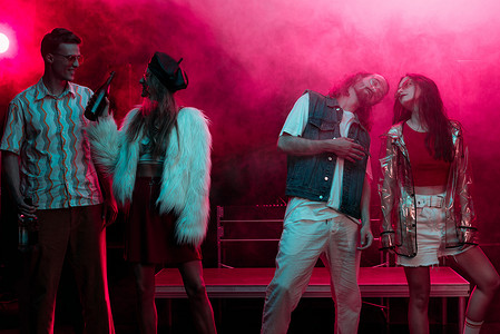 跳舞烟雾摄影照片_男人和女人与酒精跳舞在夜总会与霓虹灯粉红色烟雾