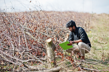 南亚农艺学家农民用剪贴板检查砍伐的树木