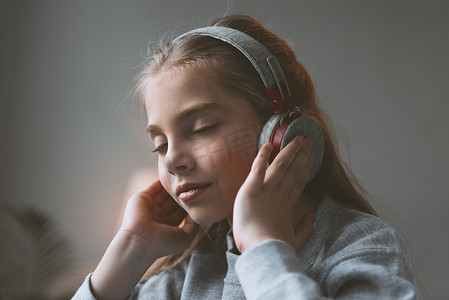 孩子听音乐的耳机的女孩