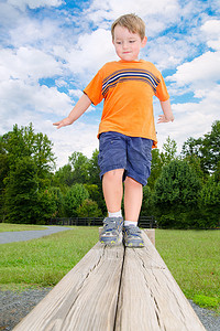 年轻的男孩或孩子上公园户外运动小径上梁障碍物的平衡