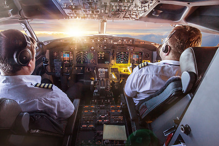 飞行棋图摄影照片_乘坐商用飞机飞行时驾驶舱中的飞行员.