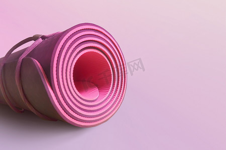 粉色半滚动瑜伽垫在洋红色背景。 健康与健康。 锻炼设备。 瑜伽和普拉提.