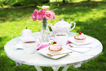 咖啡桌上的茶杯和好吃的蛋糕，在花园里