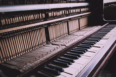 老式钢琴摄影照片_老断废弃钢琴与损坏老式复古筛选键.