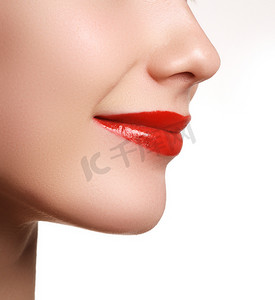 女性嘴唇的特写，化妆明亮。女人脸的宏观。时尚唇彩与红色唇膏