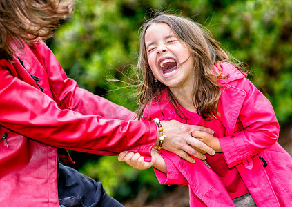 Happy pretty little girl playing with her mother