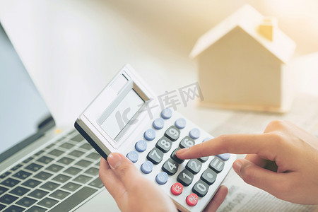 女会计或银行工作人员在办公室用计算器计算房屋贷款信贷官僚机构.