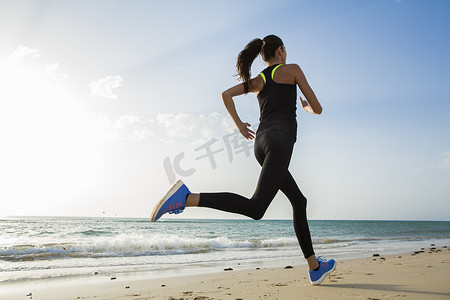 口肌训练摄影照片_运动女孩在外面训练。她在海边跑步.