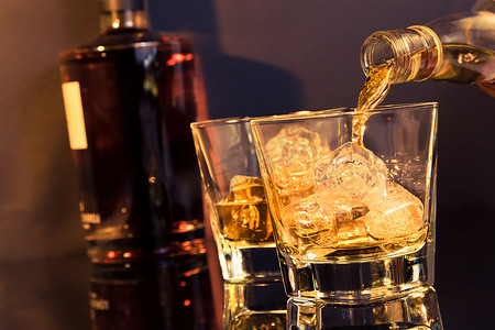 酒保倒在威士忌玻璃和瓶威士忌