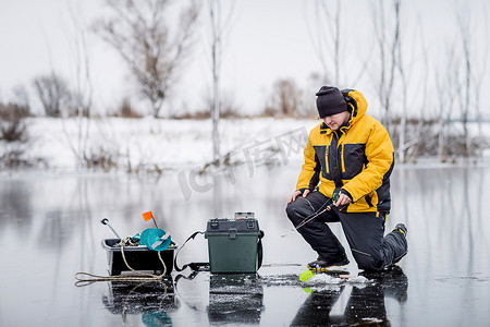 冰在结冰的湖钓鱼的人.
