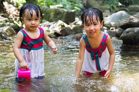 亚洲小的中国女孩在小河里玩耍