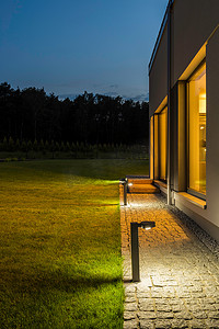 别墅夜间摄影照片_在夜间照明的别墅后院