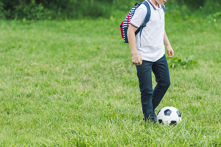 在草地上玩足球的孩子裁剪镜头